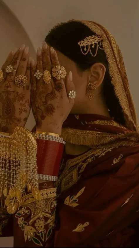 Bride in a deep red dupatta showing her choora and kaleere