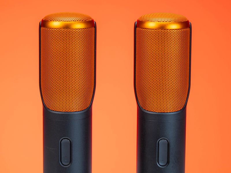 Two wireless microphones on an orange background