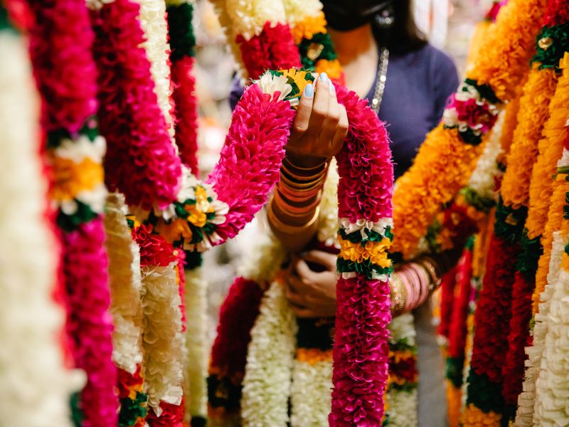 Colourful flower garlands hanging together for a Milni ceremony