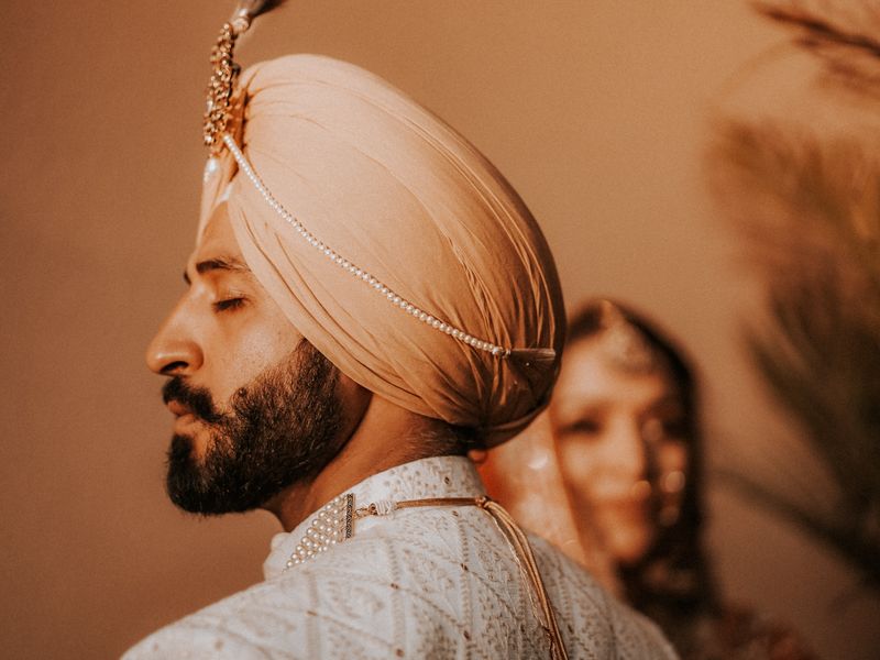 Sikh groom wearing a wedding pagh with a kalgi and pearl mala